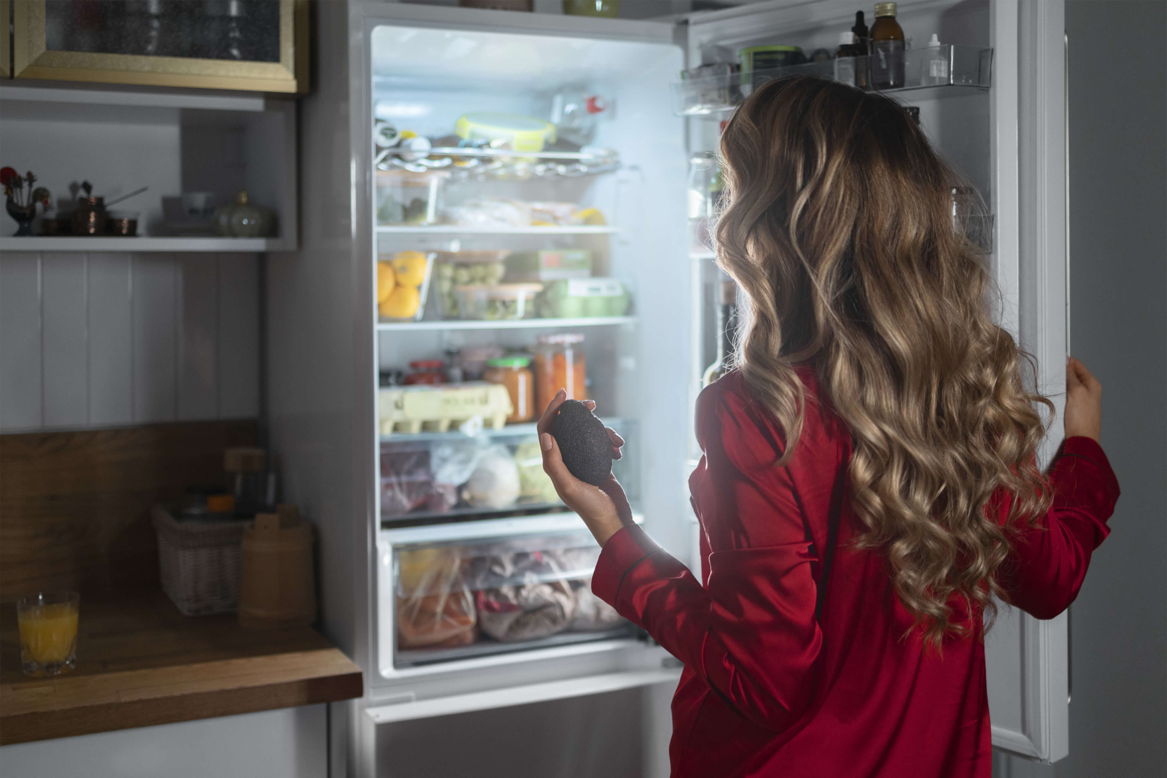 medium-shot-woman-checking-fridge-night 2